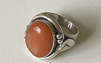 A ring of sterling silver mounted with oval polished amber. Size app. 52.