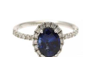 A sapphire and diamond ring set with an oval-cut sapphire and numerous brilliant-cut diamonds, mounted in 14k white gold. Size 55.