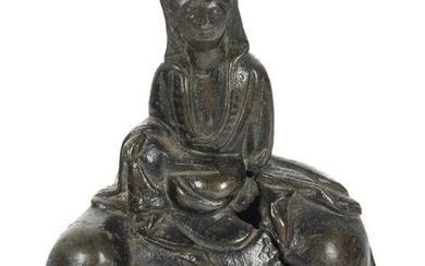 A small bronze figure of a Guanyin seated on a mythical