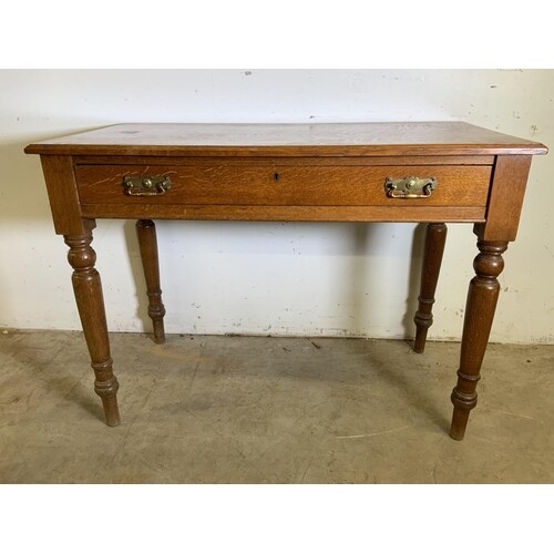An early 20th century golden oak desk with large central dra...