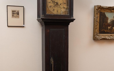 An oak longcase clock by J Bartholomew Sherborne (Dorset) UK with engraved brass dial beneath blind fret work. Bears label for the British Antique Dealers Association. Height 210 x 56 x 25cm