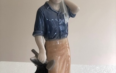 Blacksmith. Porcelain figurin decorated in under glaze colours. Royal Copenhagen, no 4502. 1. sort. H. 22 cm.
