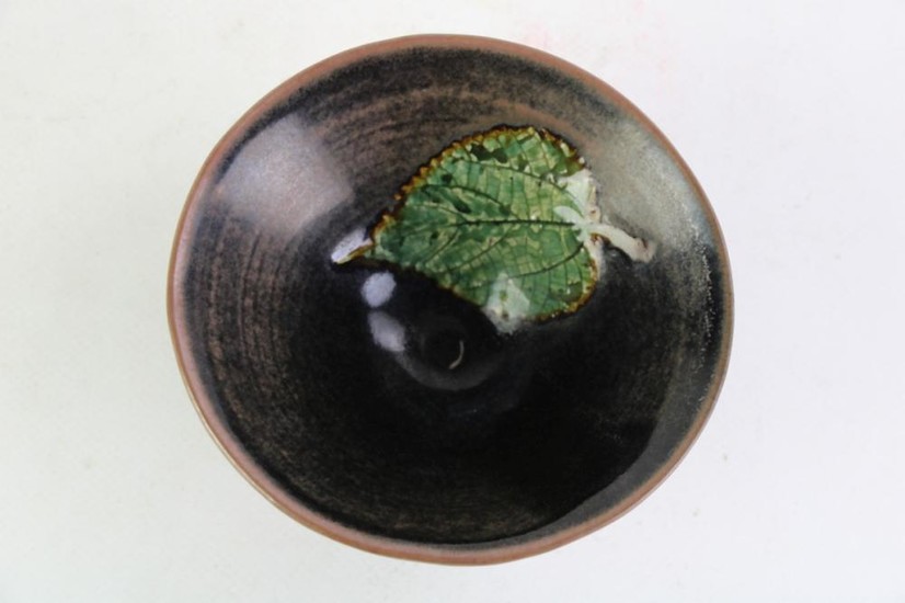 Chinese black glazed bowl, green leaf decor to interior (H7cm Dia12.5cm)