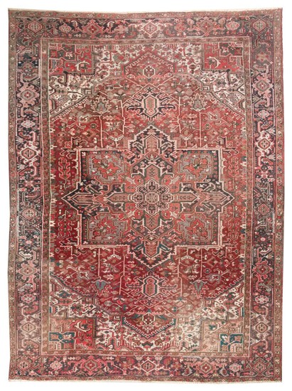 ORIENTAL RUG: HERIZ 9'4" x 12'5" Dark red field contains a gabled medallion in faded shades of charcoal, red and ivory. Ivory subfie.