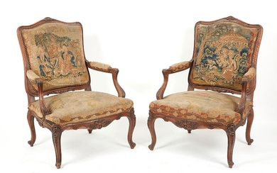 Paire de fauteuils à dos plat en bois naturel mouluré et sculpté de feuillages, palmettes...