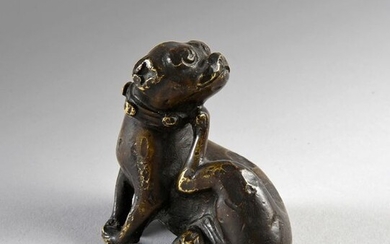 Rare bronze figure of a dog wearing a collar with bells and scratching its ear.