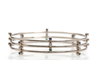 Sapphire, emerald and diamond bangle set with numerous faceted sapphires, emeralds and...