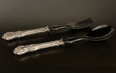Spoon and fork for serving from the 19th century. 800 silver handles in a special and impressive design and a carved head from horn. Length 24 cm