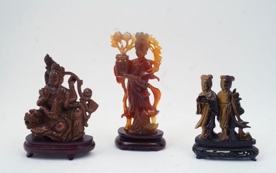 Three Chinese figurative hardstone carvings, 20th century, comprising a carnelian agate carved with a lady holding flower basket, 21cm high, a tigers eye carving of two ladies, 12cm high, and a sun stone carving of goddess riding a dragon, 16cm...