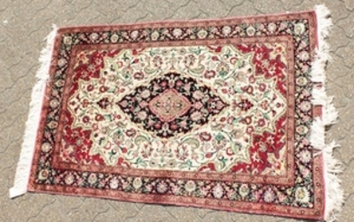 A FINE PERSIAN QUM SILK RUG with a central oval motif