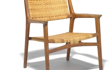 Hans J. Wegner: “JH 516”. Armchair of patinated oak. Seat and back with woven cane. Made by Johannes Hansen.