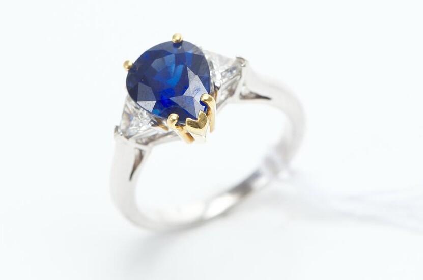A CEYLONESE SAPPHIRE AND DIAMOND RING IN TWO TONE 18CT GOLD, THE PEAR CUT BLUE SAPPHIRE WEIGHING 3.30CTS AND DIAMONDS TOTALLING 0.70...