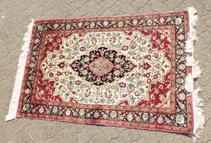 A FINE PERSIAN QUM SILK RUG with a central oval motif