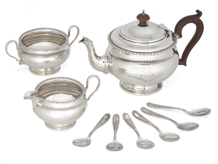 A George V silver three-piece tea set, Birmingham, c.1926, Mappin & Webb, comprising teapot, sugar and jug (jug not shown in photo, further images available upon request), each of rounded form with gadrooned rim, the teapot with wooden handle and...