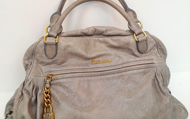 A Miu Miu Vitello Leather Handbag. Textured grey leather ext...