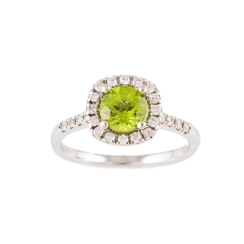 A PERIDOT AND DIAMOND CLUSTER RING, mounted in white metal. ...