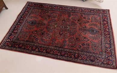 A Persian floral woollen carpet with intricate vase design on...