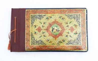 A Persian photograph album with lacquered boards, one decorated with an enamel panel depicting birds