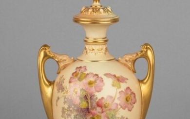 A Royal Worcester vase and cover of urn form with gilt loop handles, 10 1/2 in. (26.7 cm.) h.