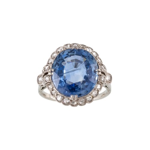 A SAPPHIRE AND DIAMOND CLUSTER RING, the large oval sapphire...