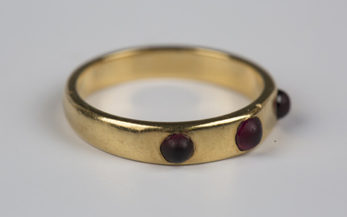 A gold and garnet three stone ring, mounted with a row of three cabochon garnets, detailed 'JB&