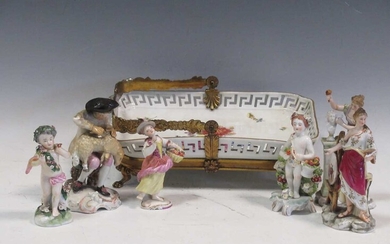 A group of continental porcelain figurines to include a sheep sheerer; together with, Sampson putti;