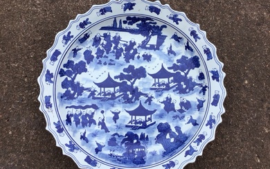 A large Chinese blue and white circular scalloped charger decorated...