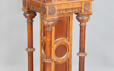 A large late Victorian Gothic Revival oak pedestal, the frieze carved with rosette medallions above