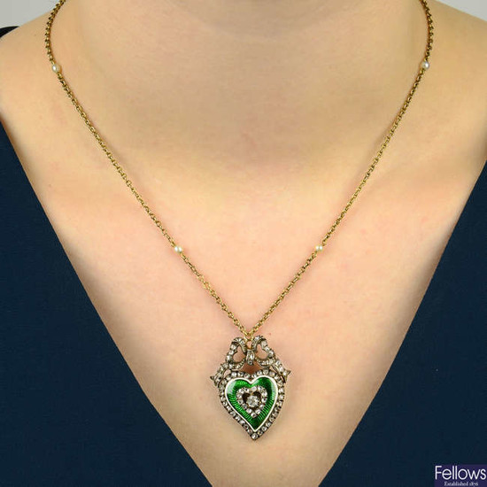 A late Victorian silver and gold, green enamel and diamond heart pendant locket, with diamond bow surmount, on seed pearl spacer chain.