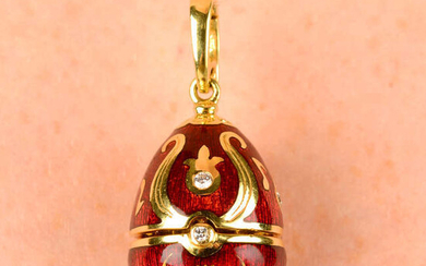 A limited edition 18ct gold diamond and red enamel hinged egg pendant, containing a treble clef, by Fabergé.