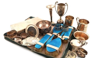 A mixed lot of silver items, various dates and makers, comprising: a five-piece silver and enamel dressing table set, plus a comb, in a fitted case, two mugs, two photograph frames, a mustard pot and spoon, a vase, a trophy cup, a bowl, six napkin...