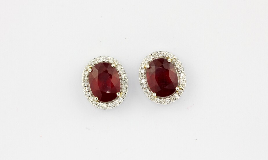 A pair of 18ct white gold (stamped 750) cluster earrings set with an oval cut ruby surrounded by brilliant cut diamonds, approx. 4.96ct rubi