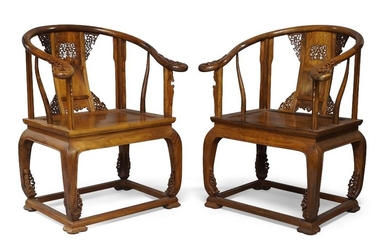 A pair of Chinese rosewood horseshoe backed armchairs, quanyi, 20th century, with horseshoe top rail terminating in scroll ends, supported by a pierced and carved back splat in scrolling foliage set on top of a square seat supported by four bracket...