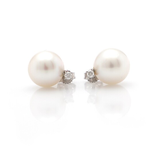 A pair of South Sea pearl and diamond ear studs each set with a cultured South Sea pearl and a diamond, mounted in 18k white gold. Pearl diam. 12.5 mm. (2)