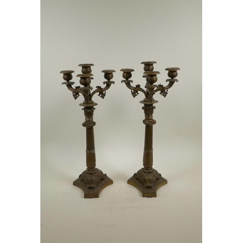 A pair of bronzed spelter three branch candlesticks on Corin...