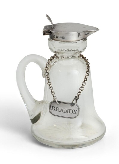 A silver mounted brandy/whisky noggin, Birmingham, 1911, Hukin & Heath, the bell-shaped glass body to silver mounted collar and cover, together with a Victorian silver decanter label, engraved 'brandy', London, 1861, Charles Rawlings & William...
