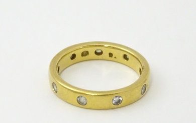 A yellow metal eternity ring set with white stones. Ring siz...