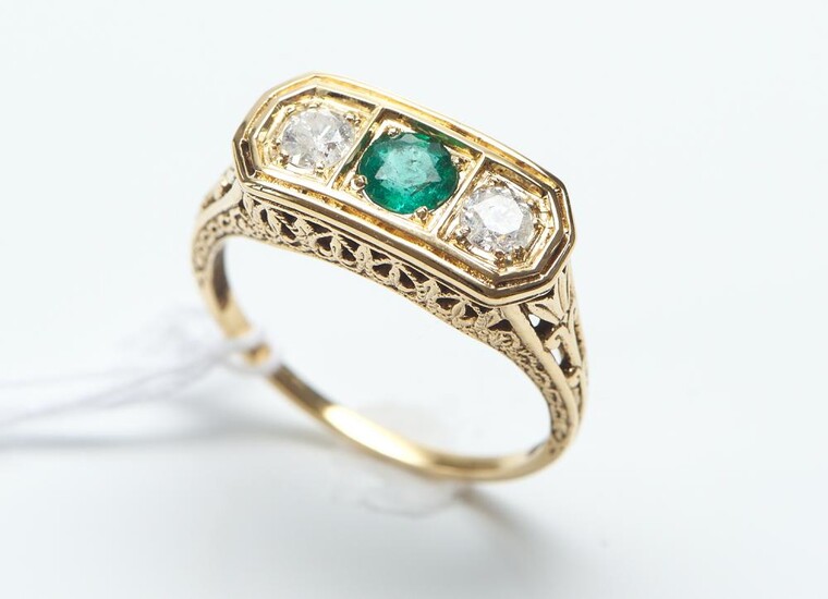 AN EMERALD AND DIAMOND RING IN 18CT GOLD, CENTRALLY SET WITH A ROUND CUT EMERALD OF 0.32CT, FLANKED BY ROUND BRILLIANT CUT DIAMONDS...