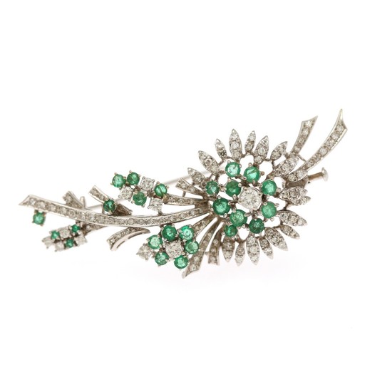 An emerald and diamond brooch set with numerous circuluar-cut emeralds and numerous brilliant-cut and single-cut diamonds, mounted in 18k white gold.
