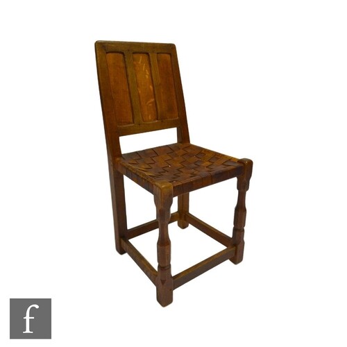 An oak side chair with triple fielded panel back over a wove...