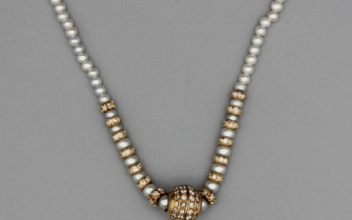 Collier de perles enrichi d’intercalaires sertis de brillants et d’un motif central stylisant une boule...
