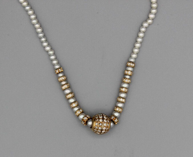 Collier de perles enrichi d’intercalaires sertis de brillants et d’un motif central stylisant une boule...