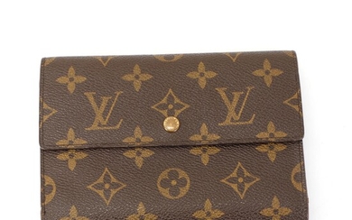NOT SOLD. Louis Vuitton: A wallet made of brown monogram canvas with three pockets, six...