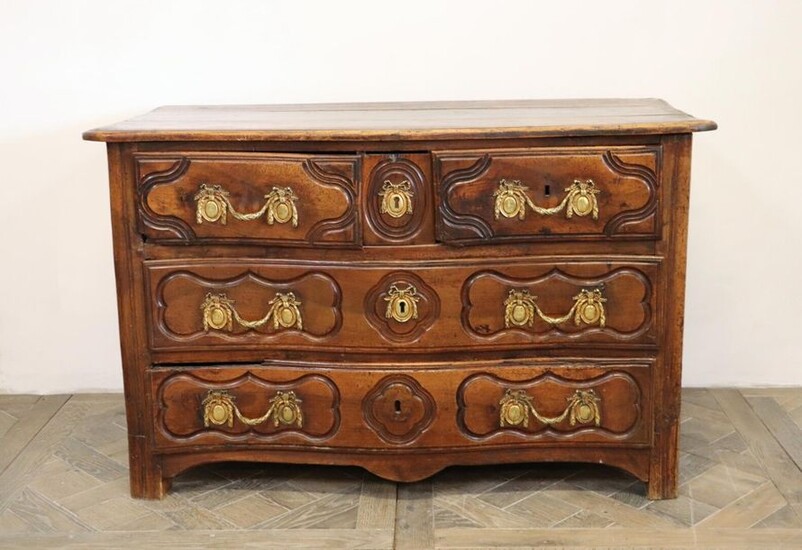 Moulded and carved natural wood chest of drawers with four drawers on three rows.