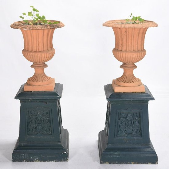 Pair of Outdoor Urns on Cast Iron Plinths.