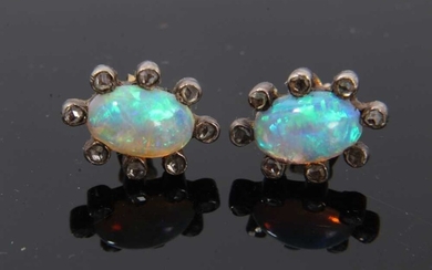 Pair of antique opal and diamond earrings, each with a opal cabochon surrounded by rose cut diamonds in silver and gold setting