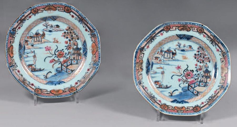 Pair of china plates. Qianlong, 18th century. Octagonal in shape, with Imari decoration and enamels of the Rose Family, in the centre of a lake landscape with a boat, pagodas and birds in a medallion of stylised floral motifs, the wing with a frieze...