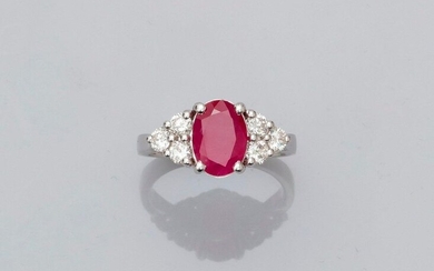 Ring in white gold, 750 MM, set with an oval ruby weighing 2.25 carats and supported by six brilliants, size: 52, weight: 4.6gr. gross.