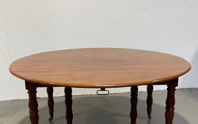 TABLE DE SALLE A MANGER en acajou reposant sur six pieds annelés, les côtés à...