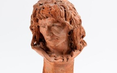 Terracotta man's head. It rests on a red marble pedestal (small accidents).
